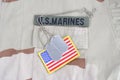 US MARINES branch tape with dog tags and flag patch on desert camouflage uniform Royalty Free Stock Photo