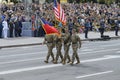 US military men, officers flying flag of USA, marching on a square, crowd of people on a background, military parade