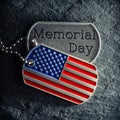 US military soldiers dog tags engraved with Memorial Day text and in the shape of the American flag Royalty Free Stock Photo