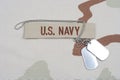 US NAVY branch tape with dog tags on desert camouflage uniform Royalty Free Stock Photo