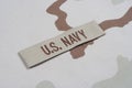 US NAVY branch tape with dog tags on desert camouflage uniform Royalty Free Stock Photo