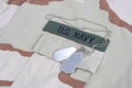 US NAVY branch tape with dog tags with dog tags on desert camouflage uniform Royalty Free Stock Photo