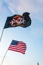 US and pirate flags blue sky Royalty Free Stock Photo