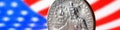 US quarter dollar coin with drummer closeup and USA flag. Stars and stripes in the blur. Beautiful banner of American patriotism Royalty Free Stock Photo