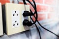 US-type power socket made from plastic mounted on room wall as equipment to connect electrical power to household appliances