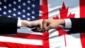 US vs Canada conflict, international relations crisis, fists on flag background Royalty Free Stock Photo