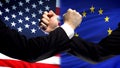 US vs EU confrontation, countries disagreement, fists on flag background