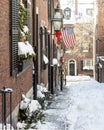 Acorn Street in the snow with the American flag flying