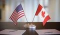 USA and Canada flags on table. Negotiation and partnership concept. 3D rendered illustration. Royalty Free Stock Photo