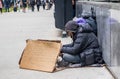 Homeless man with a cardboard sign, begging, downtown
