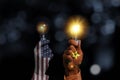 USA and China flag print screen on fist hand which holding lightbulbs which China `s lamp glowing more than USA.