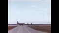 Cold War era USAF cargo plane taxiing on runway to take off. Archival video