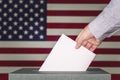 usa elections the hand of man putting his vote in ballot box against the background of the flag of the united States of America Royalty Free Stock Photo
