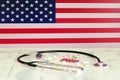 USA flag on the background of tablets, stethoscope and syringe on the table. US flag and medical supplies