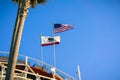 The USA flag and the California Republic flag blowing in the wind on top of a roller coaster Royalty Free Stock Photo