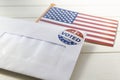 USA flag and Envelope containing voting ballot papers being sent by mail for absentee vote in presidential election