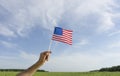 USA flag in hand. Festive USA flag in hand against blue sky and summer natural landscape. American holidays concept. Royalty Free Stock Photo
