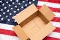 USA flag with open shipping box. Delivery from the USA. Empty postal box on American flag Royalty Free Stock Photo