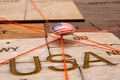 USA flag on the pushpin and red threads on the wooden map