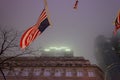 USA Flag Waving in the Wind with a Low Angle View of a Skyscraper in Background. New York City Manhattan on a Foggy Night. USA Royalty Free Stock Photo