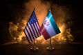 USA and Iran small flags on burning dark background. Concept of crisis of war and political conflicts between nations