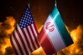 USA and Iran small flags on burning dark background. Concept of crisis of war and political conflicts between nations