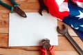 USA Labor day concept. Different kinds wrenches and pliers and white mockup blank with American flag on wooden table.