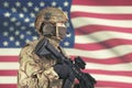 USA male soldier with machine gun in hand and American flag on background Royalty Free Stock Photo