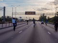 Gang of bikers performing wheelies on highway under road safety sign Royalty Free Stock Photo