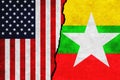 USA and Myanmar painted flags on a wall with a crack. United States of America and Myanmar relations.