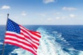 USA national flag on cruise ship with wake or trail on ocean surface Royalty Free Stock Photo