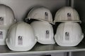 USA, New York, Ellis Island - May 2019: Shelf full of white hard hats showing `save Ellis Island` logo - focus on foreground lef