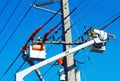 Electrical utility workers on crane repairing problem with power line Royalty Free Stock Photo