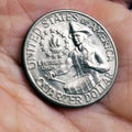 The USA quarter dollar coin with drummer lies in a palm close-up. Square illustration about American patriotism and Independence Royalty Free Stock Photo