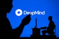 USA, SEATTLE, JANUARY 30, 2023: DeepMind from Google. Balancing the Digital Life: Man with Smartphone and Web Developer Silhouette