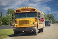 USA yellow school bus stopping on rural road with car stopped behind it Royalty Free Stock Photo