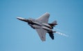 USAF F-15E Strike Eagle fighter jet flying with afterburners in blue sky