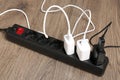 USB adapters with charge cables in power strip on floor, closeup Royalty Free Stock Photo