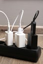 USB adapters with charge cables in power strip on floor indoors, closeup Royalty Free Stock Photo