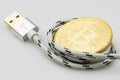 USB cable curled around Bitcoin cryptocurrency coin on white background Royalty Free Stock Photo