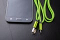 A usb cable for data transfer and phone charging. Telephone and accessories on the table Royalty Free Stock Photo