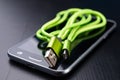 A usb cable for data transfer and phone charging. Telephone and accessories on the table Royalty Free Stock Photo