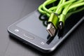 A usb cable for data transfer and phone charging. Telephone and accessories on the table Royalty Free Stock Photo