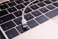 USB cable with lightning connector and laptop keyboard, closeup Royalty Free Stock Photo