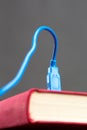 Usb cable plugged into a book Royalty Free Stock Photo