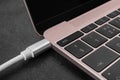 USB cable plugged into laptop port on dark table, closeup Royalty Free Stock Photo