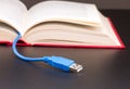Usb cable sticks out from red book Royalty Free Stock Photo
