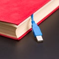 Usb cable sticks out from red book Royalty Free Stock Photo