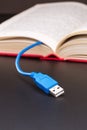 Usb cable sticks out from red book Royalty Free Stock Photo