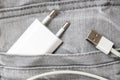 Usb charger, wire and adapter plug in grey jeans pocket, dont forget charger at home Royalty Free Stock Photo